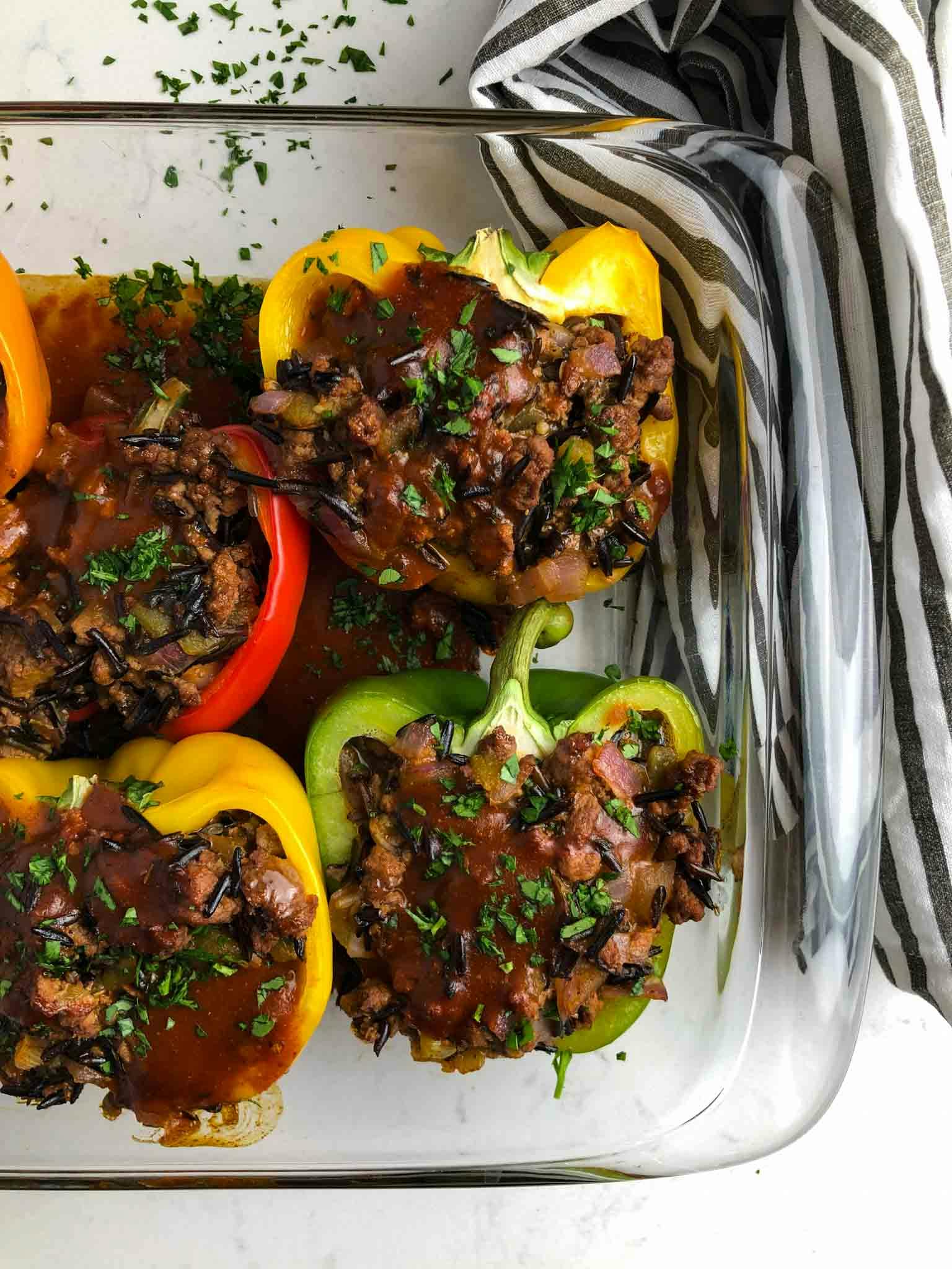 Beef enchilada stuffed peppers in a glass container.