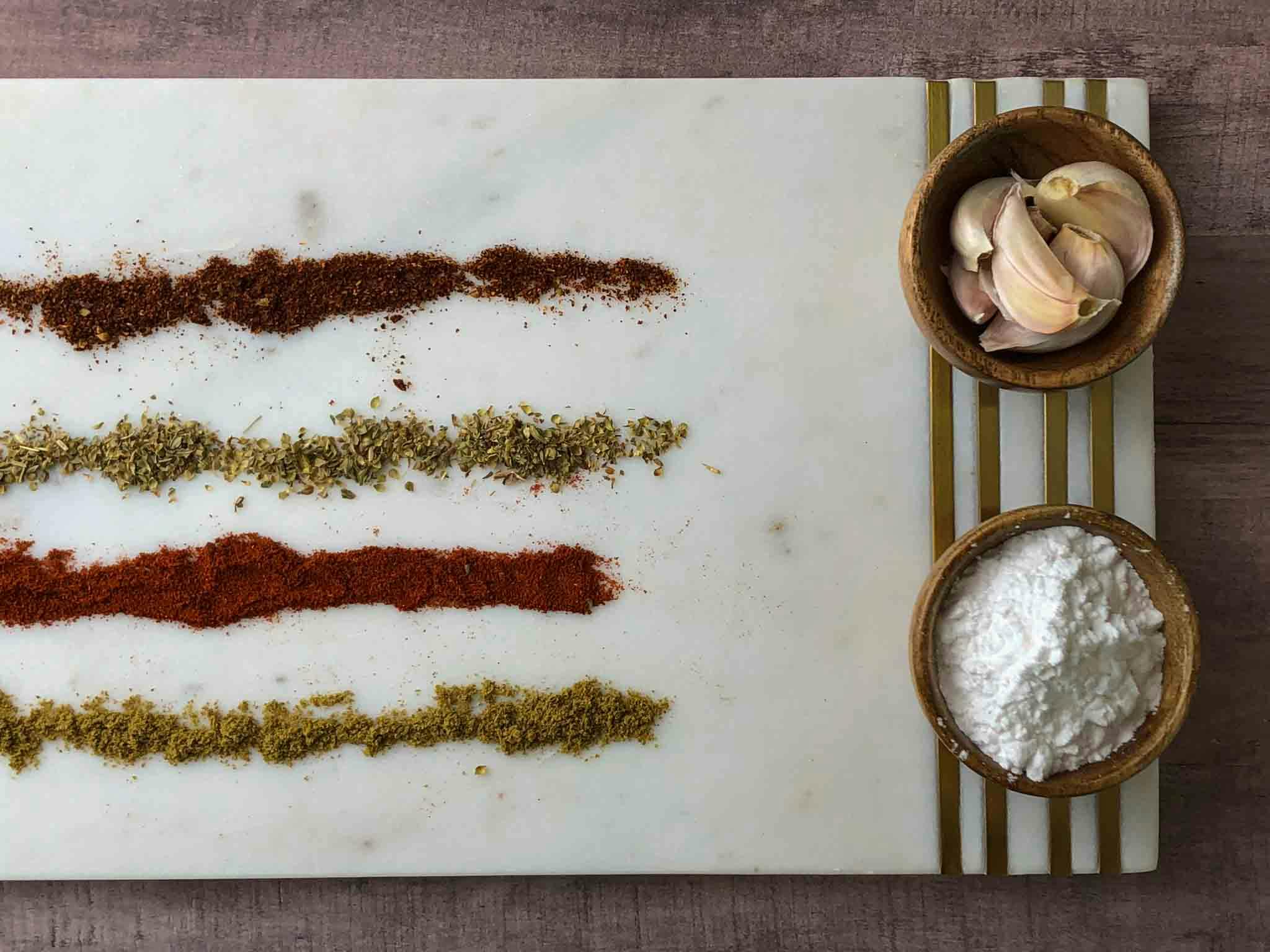 All spices on a serving platter in lines.