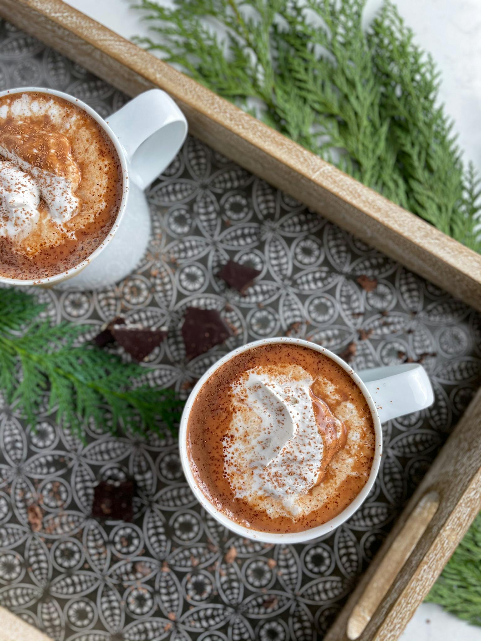 Two mugs of healthy hot chocolate on a tray.
